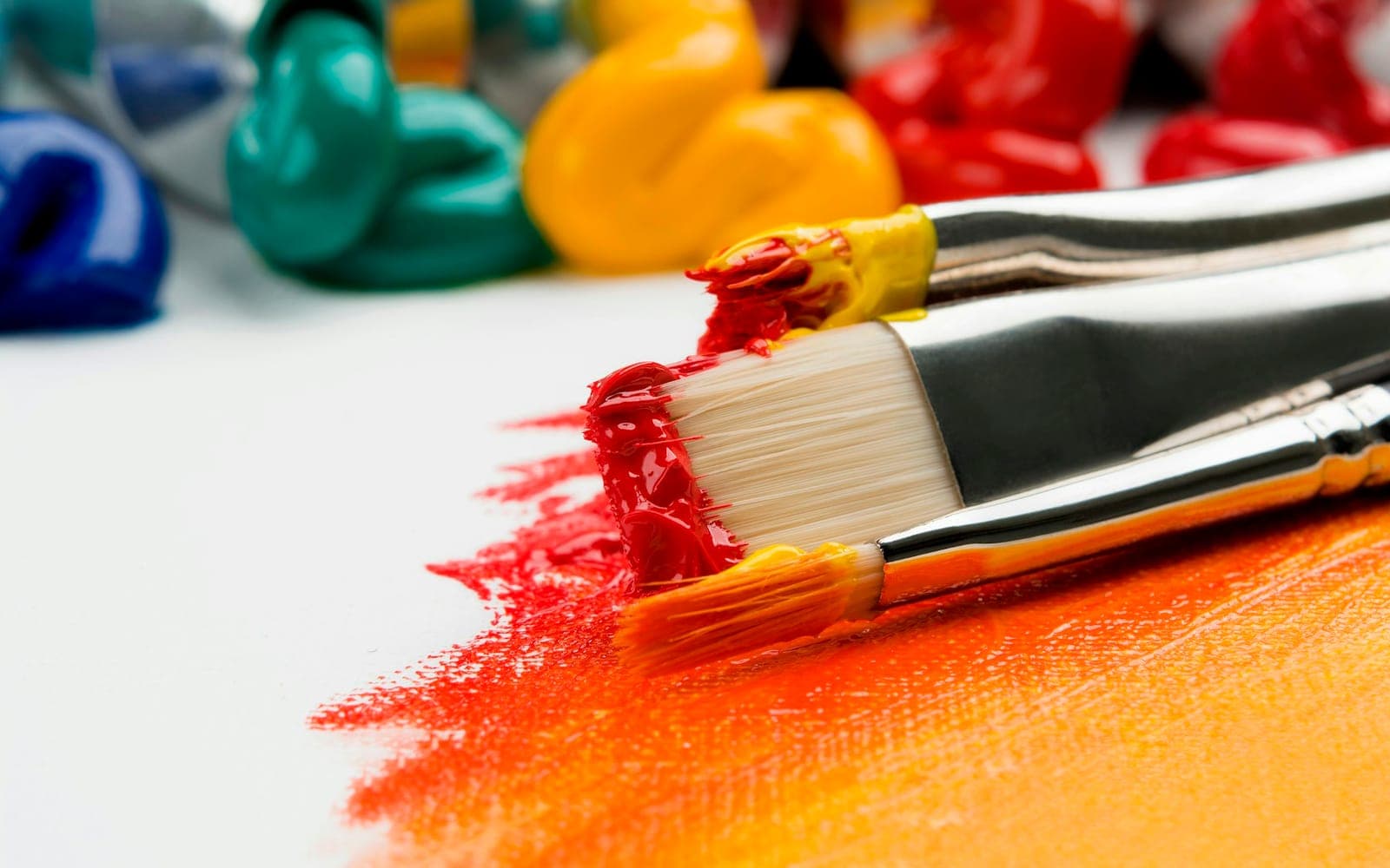 Paintbrushes with red and yellow paint on a canvas for vector-style art