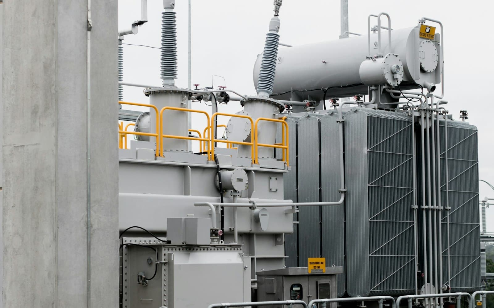 Close-up of a large power transformer with cooling fins and bushings