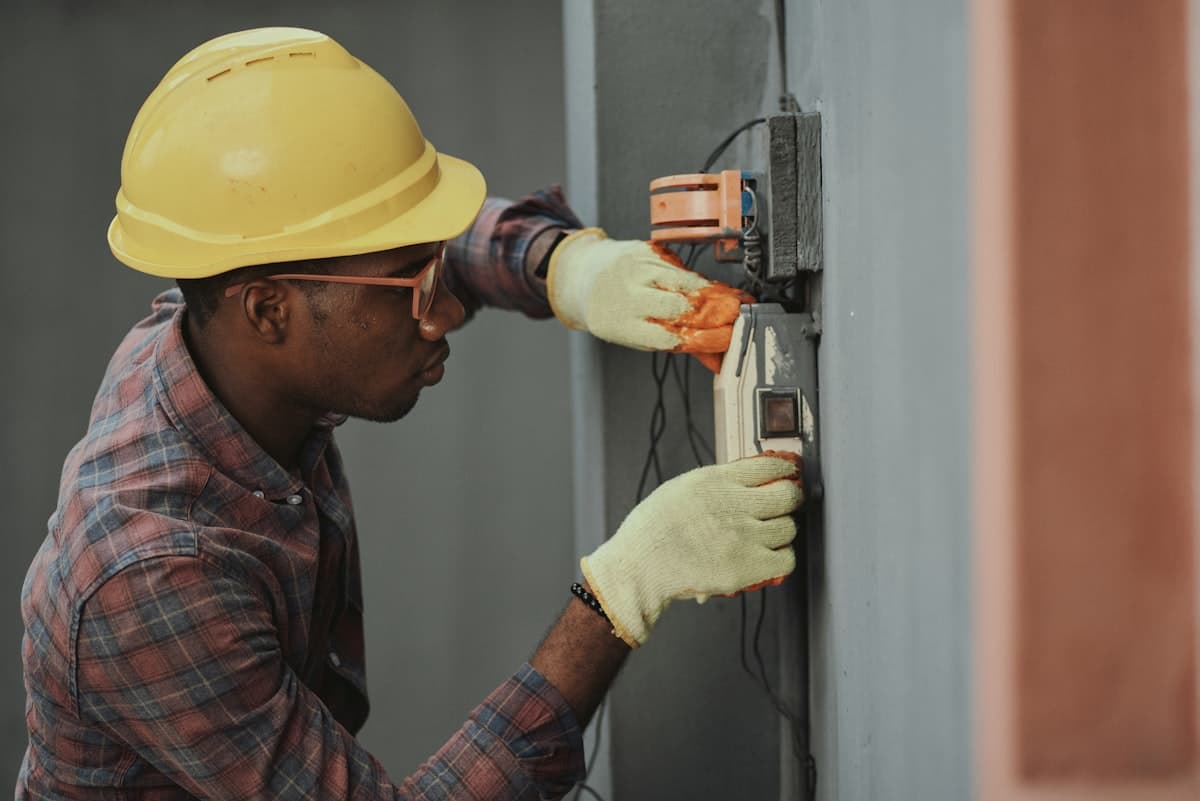 Electrical installations blueprints and technician working on wiring systems
