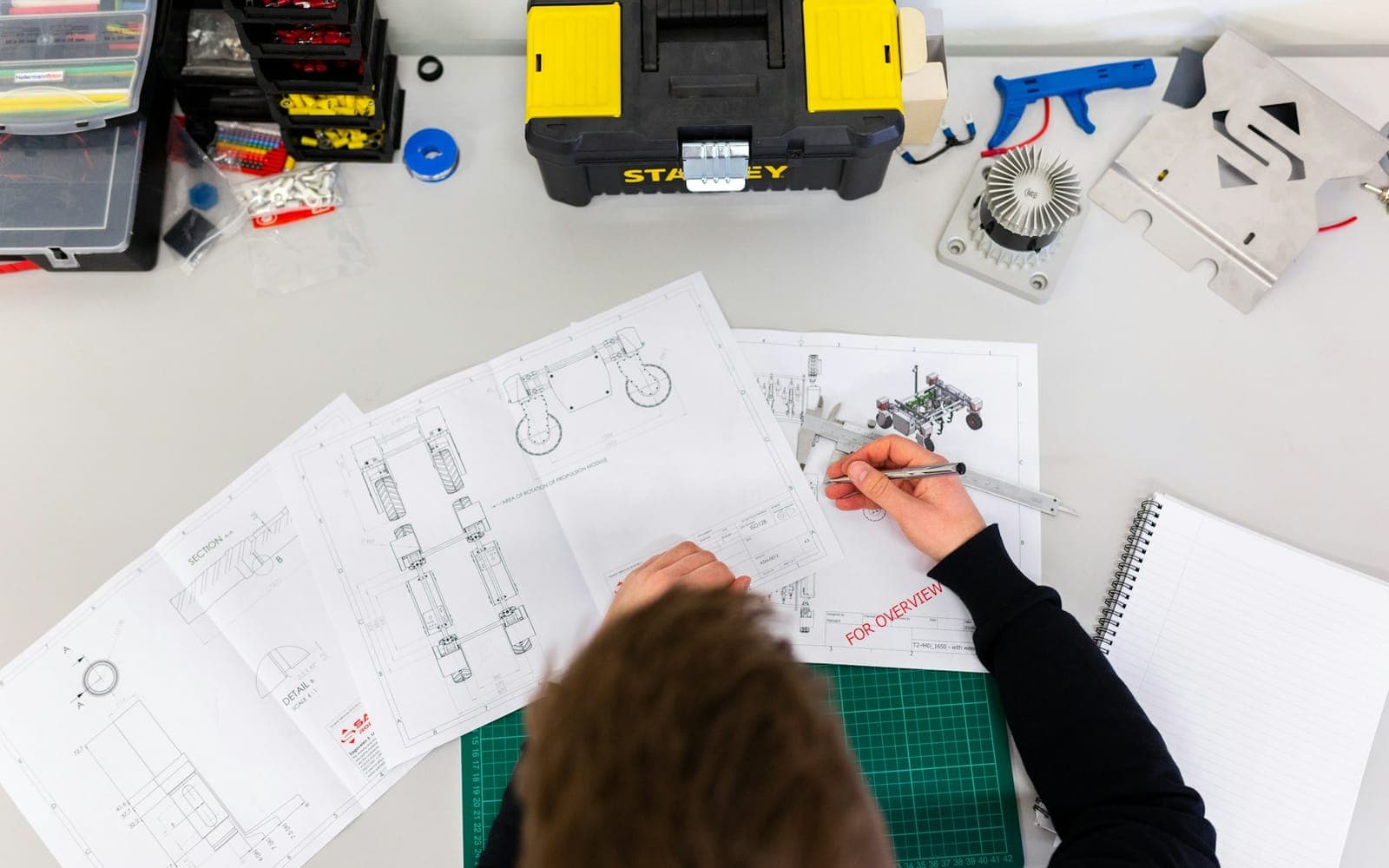 Engineer inspecting manufactured parts on a factory bench