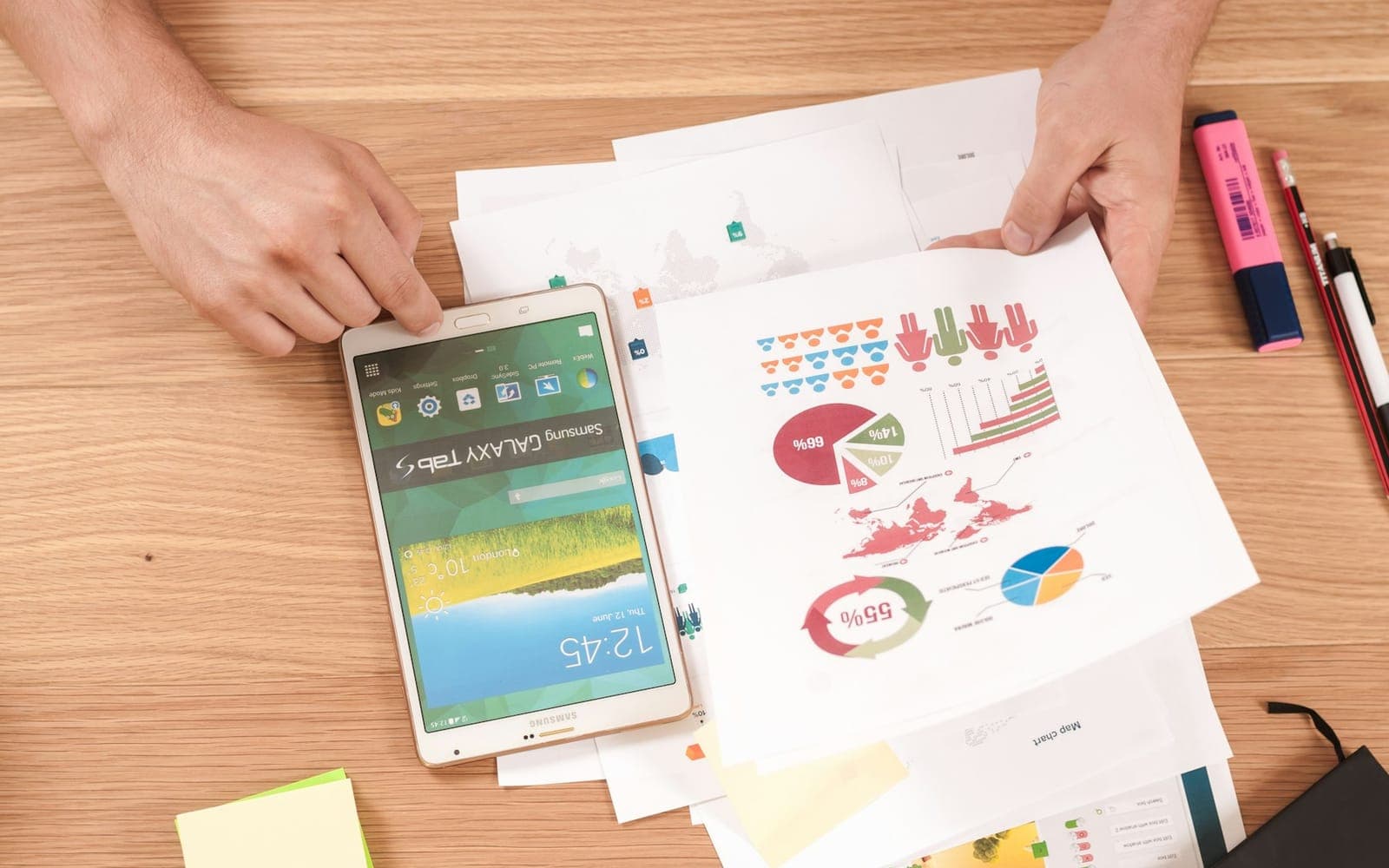 Project manager reviewing colourful charts, KPIs and a tablet on a desk