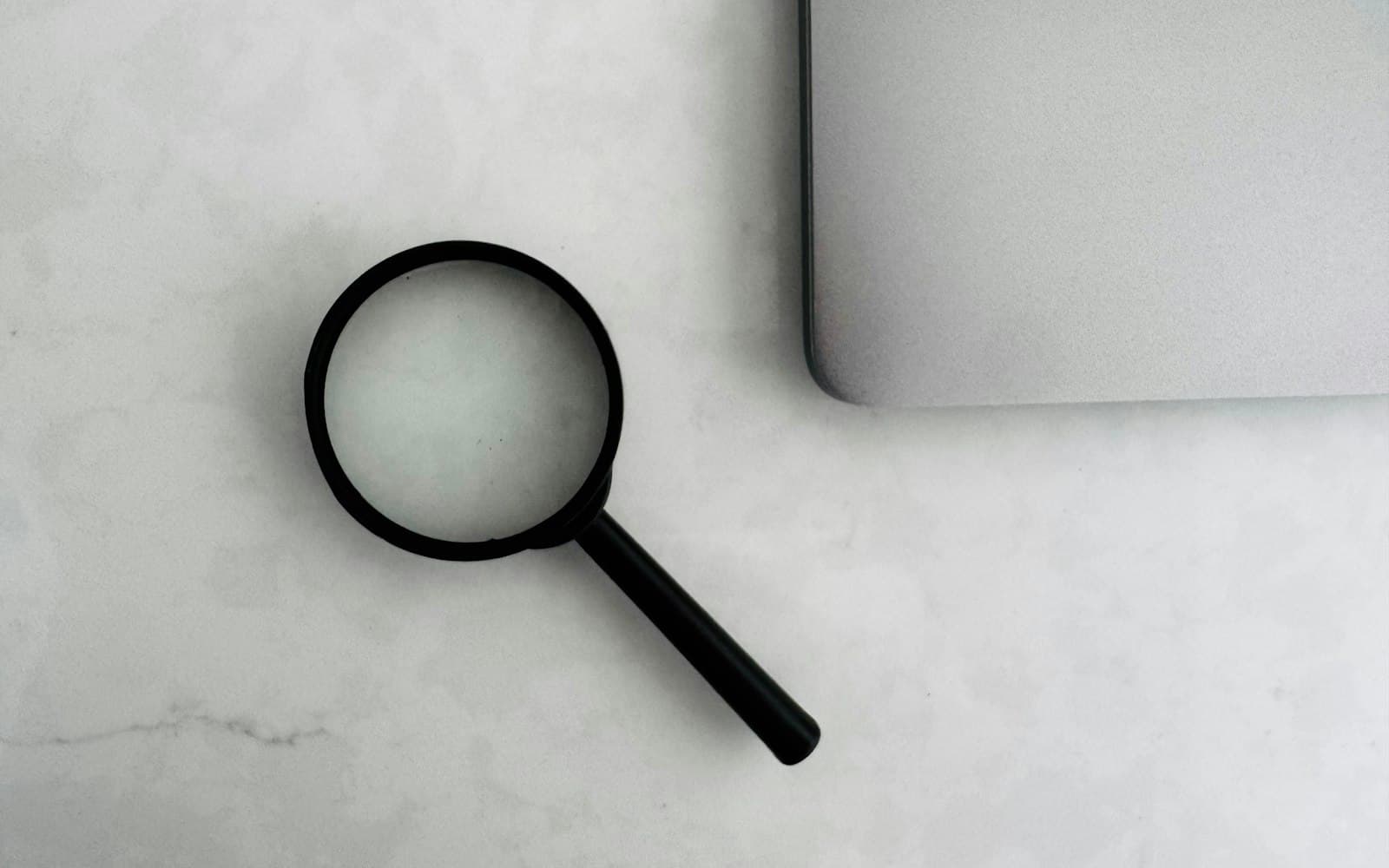Magnifying glass on a white desk, ready to inspect the root cause