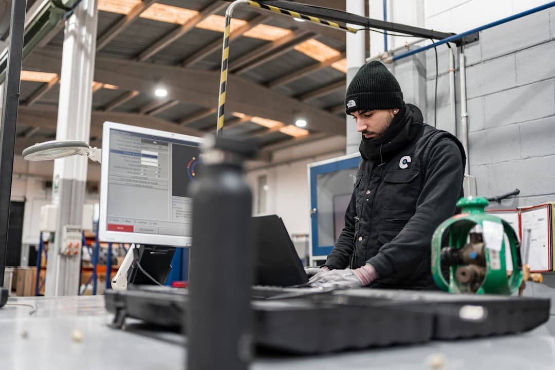 Engineer programming automation software on a computer in a plant